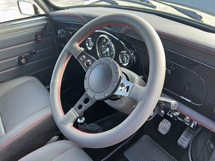 Bespoke Moto-Lita steering wheel paired with a sleek black walnut dashboard in the Mini Spectre.