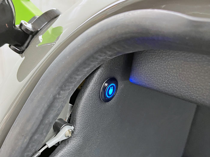Close-up of the bi-directional charging button on the Mini Spectre’s advanced EV system.