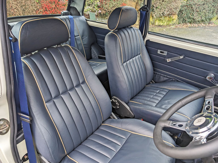 Dark blue leather seats in a classic Mini revitalised and restored with the leather connolising process.