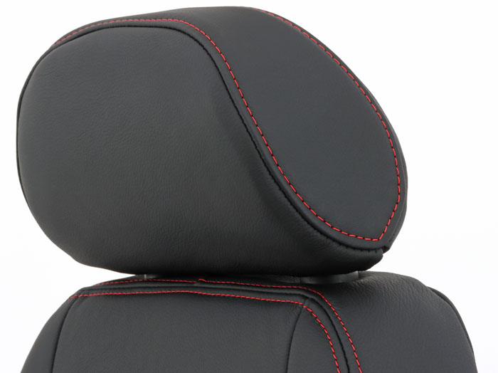 Close-up of a black leather headrest with detailed red stitching in a bespoke classic Mini.