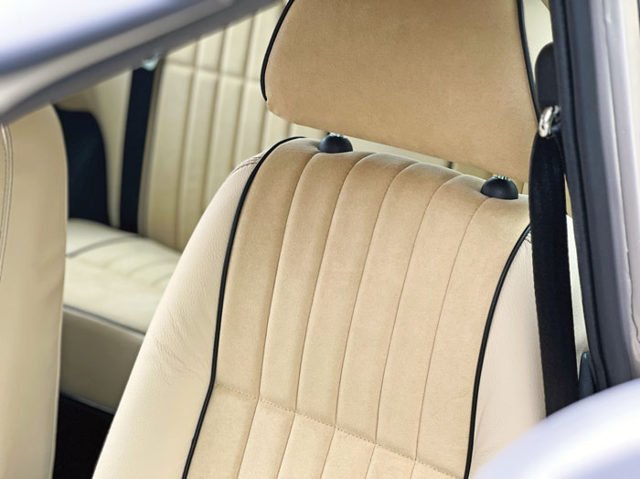 Close-up of a bespoke Alcantara and leather seat with intricate stitching detail in a classic Mini.
